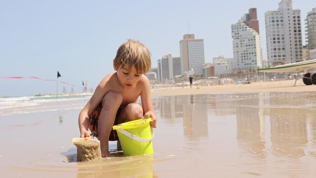 Child, boy, playing on the beach in Tel Aviv in the evening, summertime