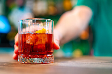 man bartender hand making negroni cocktail in bar