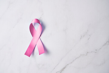 Pink ribbon on white marble background, breast cancer concept, breast cancer awareness, breast...