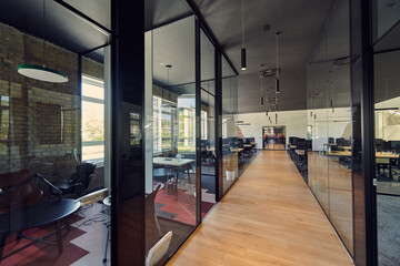 In a setting of modern, glass-walled business startup offices, the open, airy workspace reflects a...