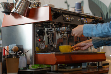 Hand of coffee shop owner making hot coffee in her shop. Bokeh light background. Small business. Own business.