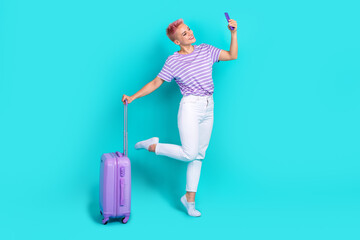 Full length body photo summer holidays funny adventures young girl selfie phone cadre hold suitcase isolated on aquamarine color background
