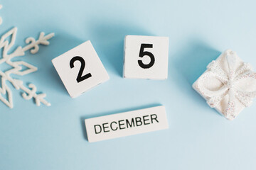 Christmas, wooden calendar with the date December 25 on a blue background with decor, flatlay. The...