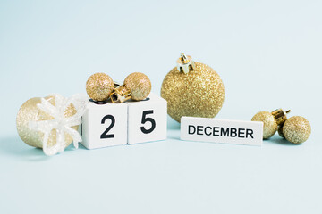 Christmas decor and wooden calendar with the date December 25 on a blue background. The concept of...