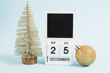 Christmas decor and wooden calendar with the date December 25 on a blue background. The concept of preparing for the celebration of Christmas and New Year and plans for the future.