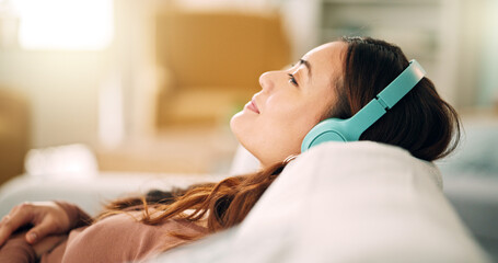 Relax, headphones and happy woman listening to music, radio or podcast while resting on sofa....