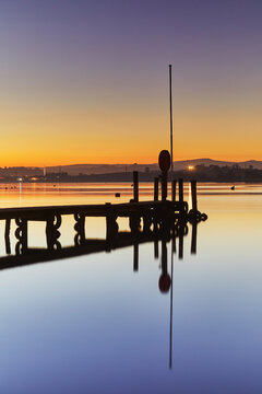A very calm dusk scene, with a wooden jetty on the estuary of the River Teign, at Coombe Cellars, near Newton Abbot, south coast of Devon, England, United Kingdom