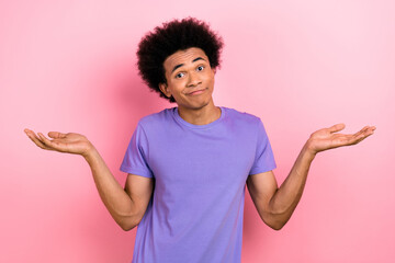Photo of clueless funky excused man with afro hairstyle dressed blue t-shirt shrugging shoulders...