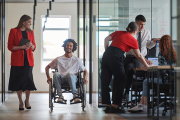 Fototapeta premium A group of young business people in a modern glass-walled office captures the essence of diversity and collaboration, while two colleagues, including an African American businessman in a wheelchair