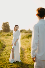 loving couple of newlyweds in a field in nature in summer. Romantic walk of lovers at sunset.