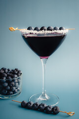 Blueberry Martini with Sugared Rim Garnished with Fresh Blueberries: A cocktail made with vodka and...