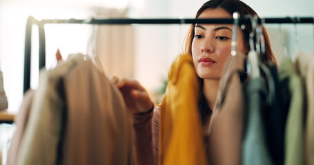 Retail clothes, happy shopping and woman in luxury designer store for fashion choice on railing in boutique. Rich Asian customer with wealth looking for clothing on discount during sale in mall