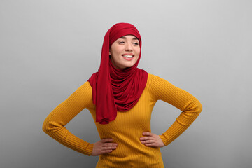 Portrait of Muslim woman in hijab on light gray background