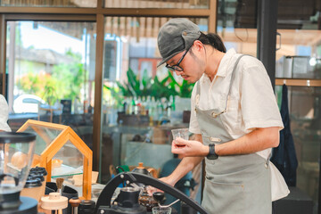Barista at a coffee shop preparing filter coffee, Cheerful barista wearing apron while preparing coffee at an automatic machine in a modern beverage cafe, Professional hipster barista making drip brew
