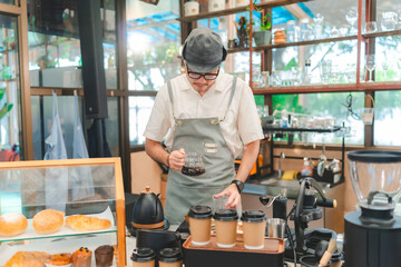 Barista at a coffee shop preparing filter coffee, Cheerful barista wearing apron while preparing coffee at an automatic machine in a modern beverage cafe, Professional hipster barista making drip brew