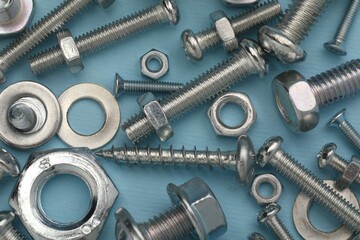 Many different fasteners on light blue background, flat lay