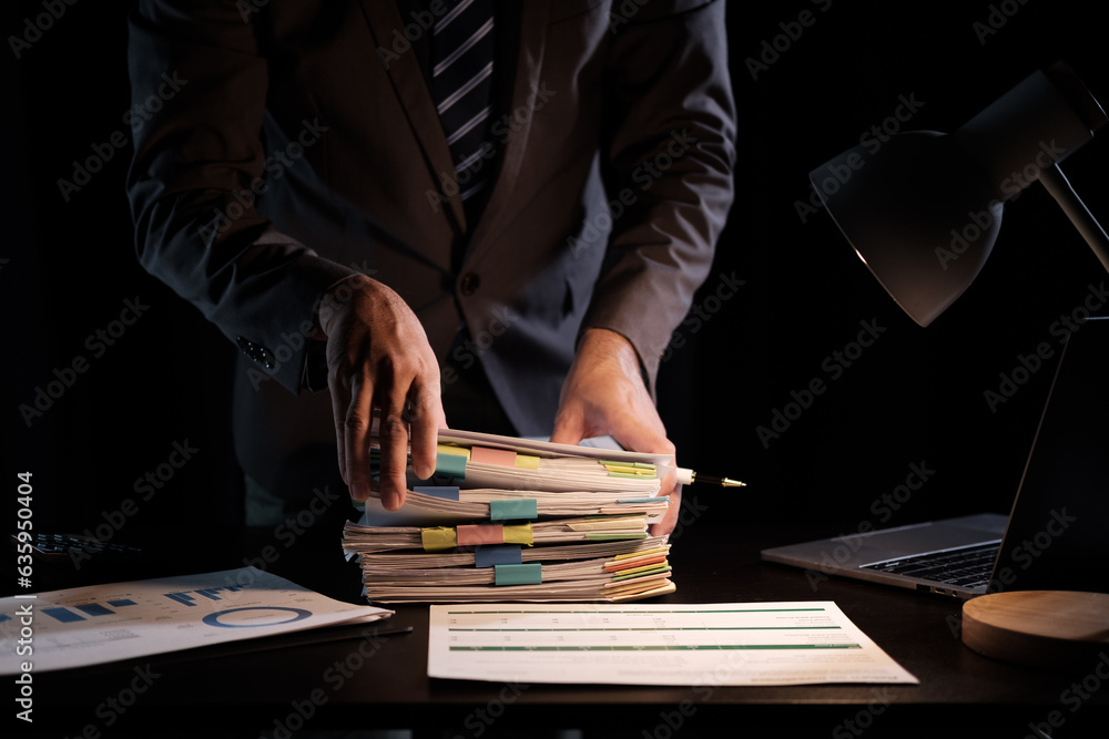 Poster Business Employee hand working in Stacks paper files for searching and check unfinished document archives on folders papers at busy work desk workplace office.