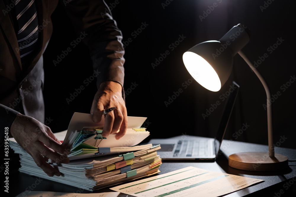 Poster Business Employee hand working in Stacks paper files for searching and check unfinished document archives on folders papers at busy work desk workplace office.