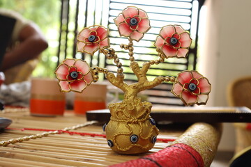 A golden Pot Devil Eye Plant with Five devil eye Flowers with a bokeh background on a table, Vastu or Fang sui Item © Prateek