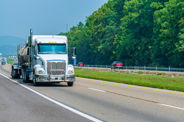Fototapeta na wymiar White Tanker Truck On Interstate Highway With Copy Space