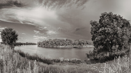 Black and white image of turn in river with storm clouds 