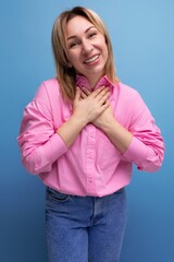 well-groomed cute blond woman with shoulder-length hair dressed in a trendy pink shirt posing in the studio