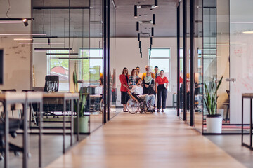 A diverse group of young business people congregates within a modern startup's glass-enclosed office, featuring inclusivity with a person in a wheelchair, an African American young man , and a hijab