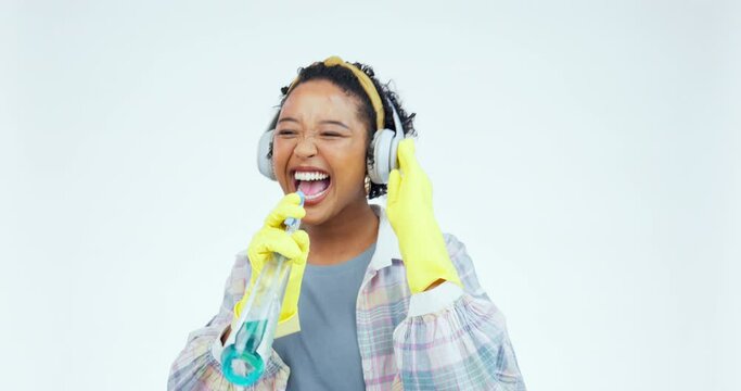 Studio, headphones and woman dance while cleaning with headphones, happy and singing on white background. Spray, cleaner and radio, podcast or music, dancing or karaoke for household spring clean