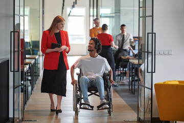 A group of young business people in a modern glass-walled office captures the essence of diversity...