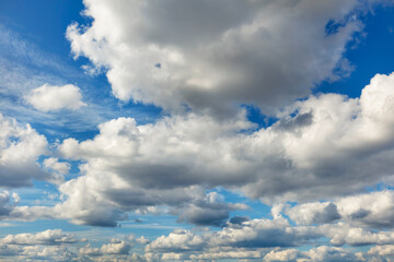 Dense clouds fill the blue sky with their gray-white caps.