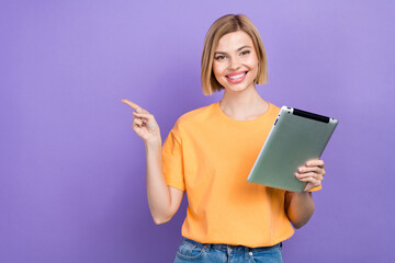 Photo of cheerful girl with bob hairstyle dressed yellow t-shirt hold tablet indicating at sale...