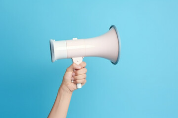 Hand holding megaphone on blue background.