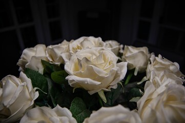 Vibrant bouquet of white roses with lush green foliage and petals