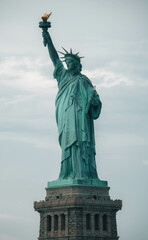 statue of liberty in over cloudy sky