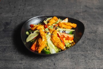 Closeup of a bowl of salad with chicken nuggets