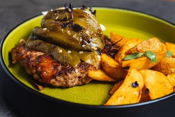 Closeup of a plate with steak served with eggplant and fries