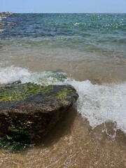sea sandy shore with sea wave and big stones