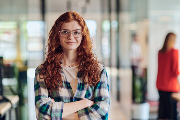 A portrait of a young businesswoman with modern orange hair captures her poised presence in a...