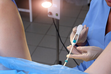 Contraceptive IUD. Installation of a birth control system. The gynecologist installs an IUD. Gynecological chair. An intrauterine contraceptive device with a copper coil used for contraception.