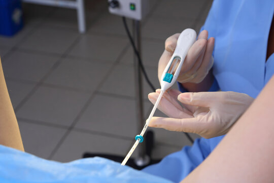 Contraceptive IUD. Installation of a birth control system. The gynecologist installs an IUD. Gynecological chair. An intrauterine contraceptive device with a copper coil used for contraception.