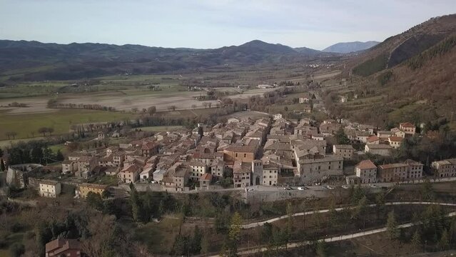 Aerial view of the old medieval village of Costacciaro in Italy surrounded by mountains