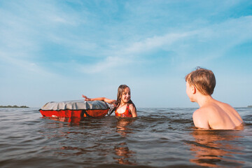 Obraz premium Children play in the water with an inflatable ring.