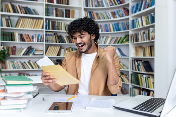 Young student received letter with good exam results and university admission confirmation,...