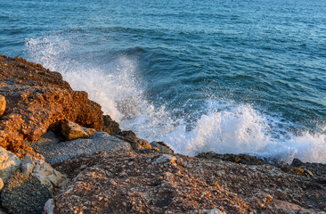 Sea surf - waves roll on stones. Sea in Malaga, Andalusia, Spain