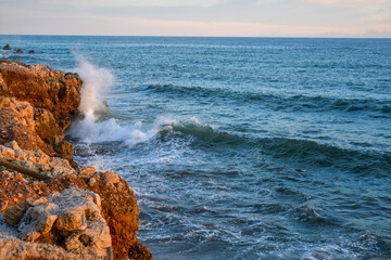 Sea surf - waves roll on stones. Sea in Malaga, Andalusia, Spain
