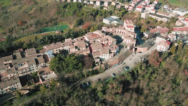 Aerial footage over traditional houses with trees and lawn in Sinalunga, Tuscany, Italy