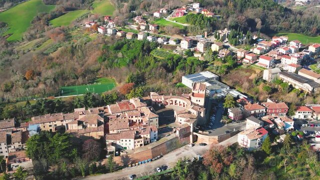 Drone footage flyover traditional houses with vegetation trees in Sinalunga, Tuscany, Italy