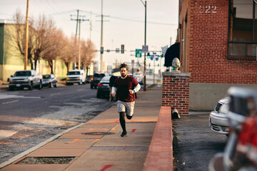 Young caucasian man jogging and exercising on a sidewalk in St Louis US