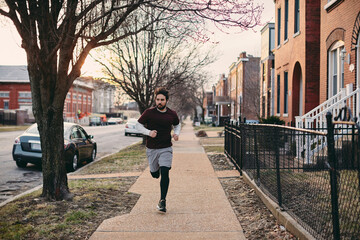 Young caucasian man jogging and exercising on a sidewalk in St Louis US