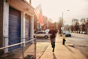 Young caucasian man jogging and exercising on a sidewalk in St Louis US